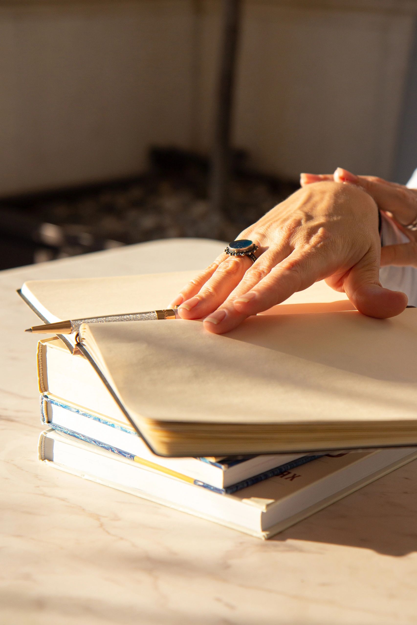 Hands writing in a journal in warm light