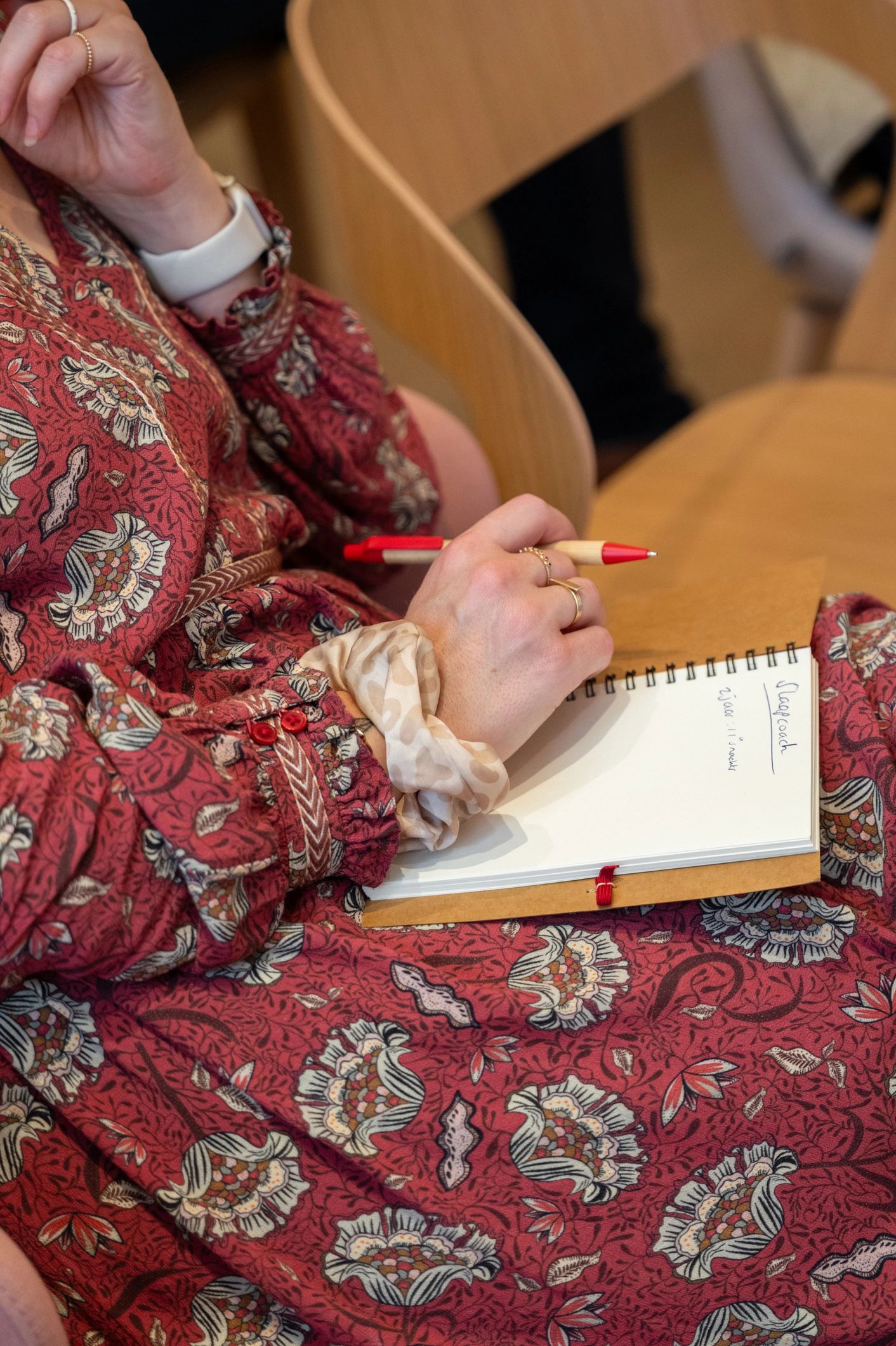 Close-up of a woman writing intentions in a notebook