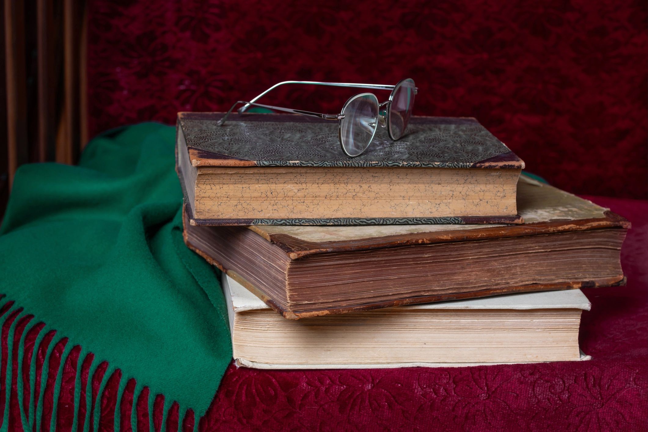 Stack of antique books on velvet surface